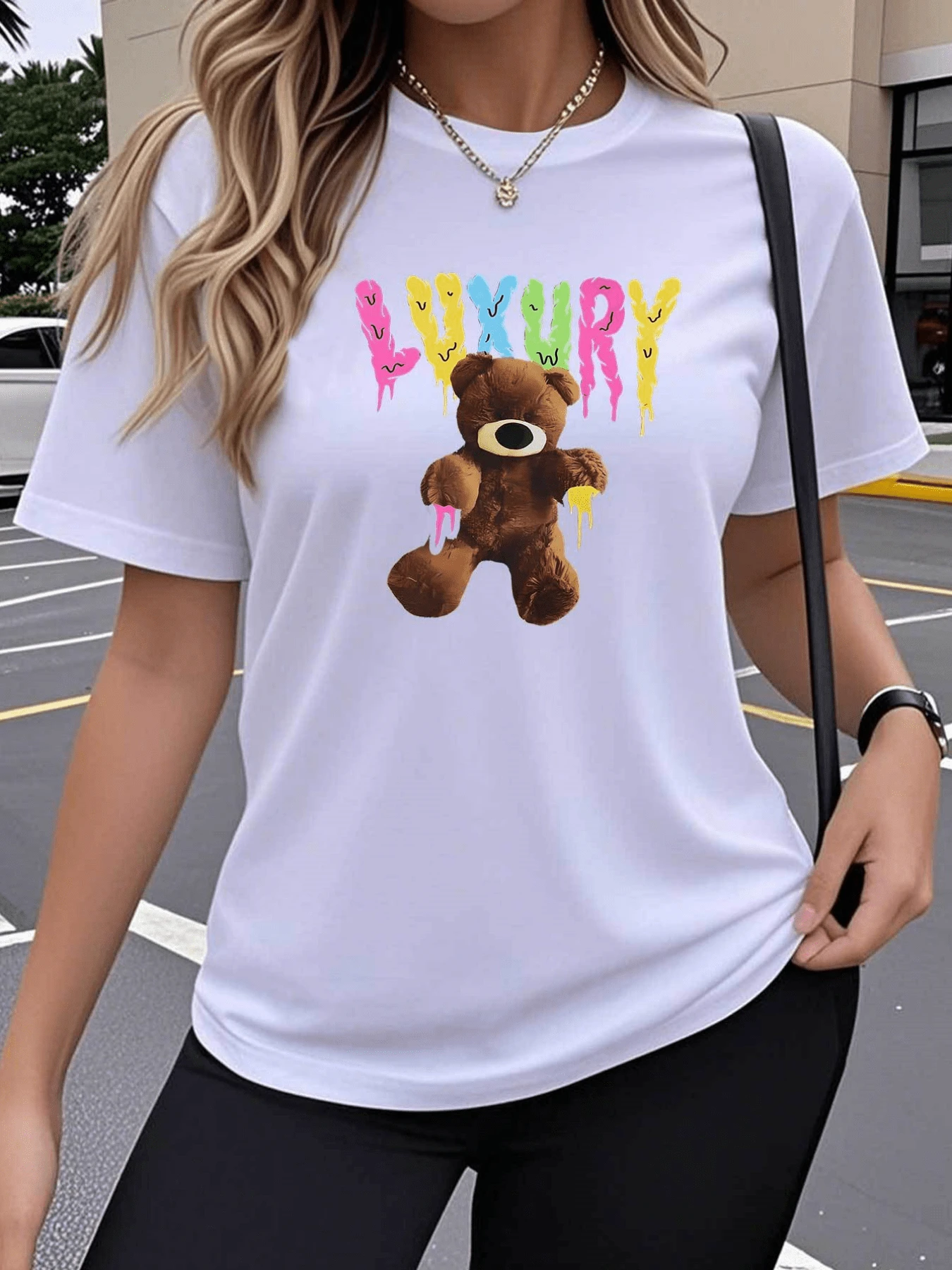 Un estampado que muestra un oso de peluche marrón con detalles coloridos y fondo con letras que evocan diversión juvenil y actitud moderna camiseta de mujer casual cómoda ideal para un look urbano elegante - Blanco - Ver 1