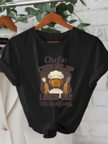 A Smiling Chef's Figure Holding Kitchen Utensils Celebrates The Spirit Of Work And Dedication In A Festive Atmosphere With A Motivational Message. A Modern, Comfortable, Casual Women's T-Shirt For Everyday Wear. - 黑色 - 查看 1