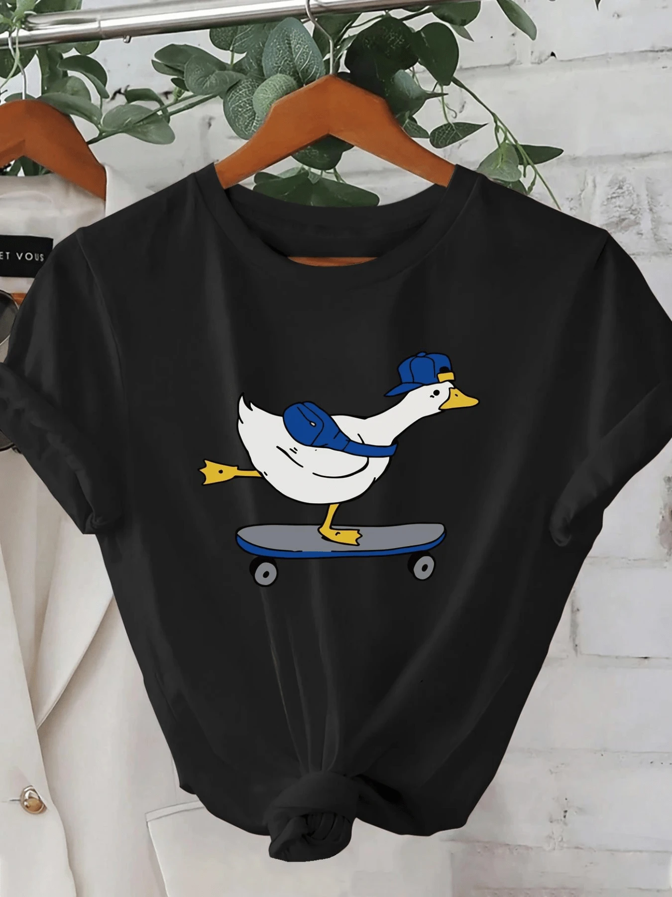 Adventurous Duck Wearing A Blue Cap On A Skateboard, Showing Free Spirit And Fun Energy. Ideal For Those Who Love Originality. Modern And Comfortable Casual Women's T-Shirt. - 黑色 - 查看 1