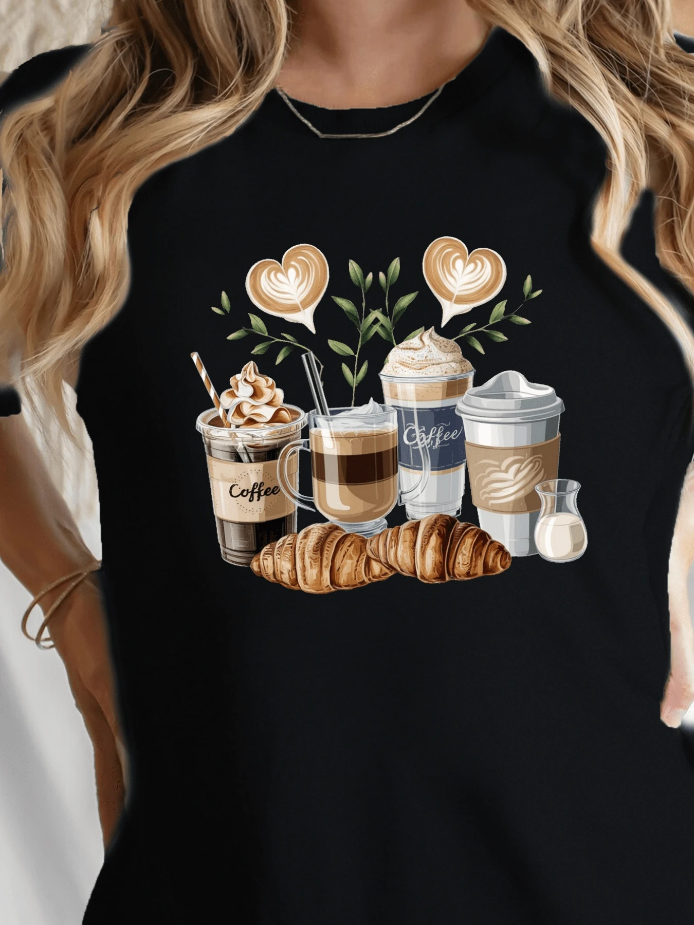 Coffee Cups With Heart-Shaped Foam Art Surrounded By Green Leaves And Croissants Evoke The Warmth Of A Peaceful Morning. Comfortable Casual Women's T-Shirt For Coffee Lovers. - 黑色 - 查看 1