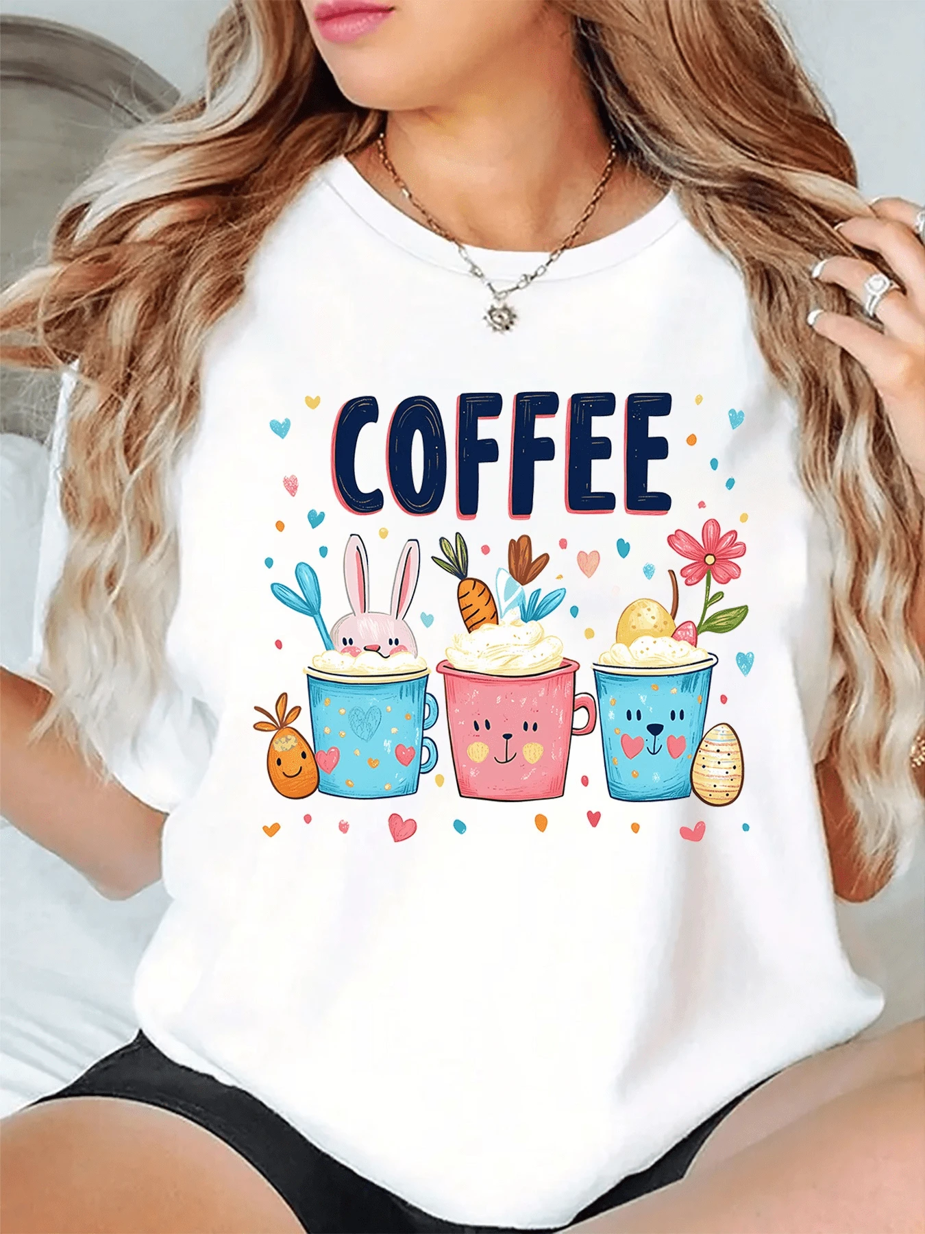 Tres tazas coloridas llenas de alegría muestran un conejo y un oso sonrientes rodeados de corazones zanahorias flores y huevos decorativos transmitiendo ternura y energía positiva camiseta de mujer casual cómoda para uso diario - Blanco - Ver 1