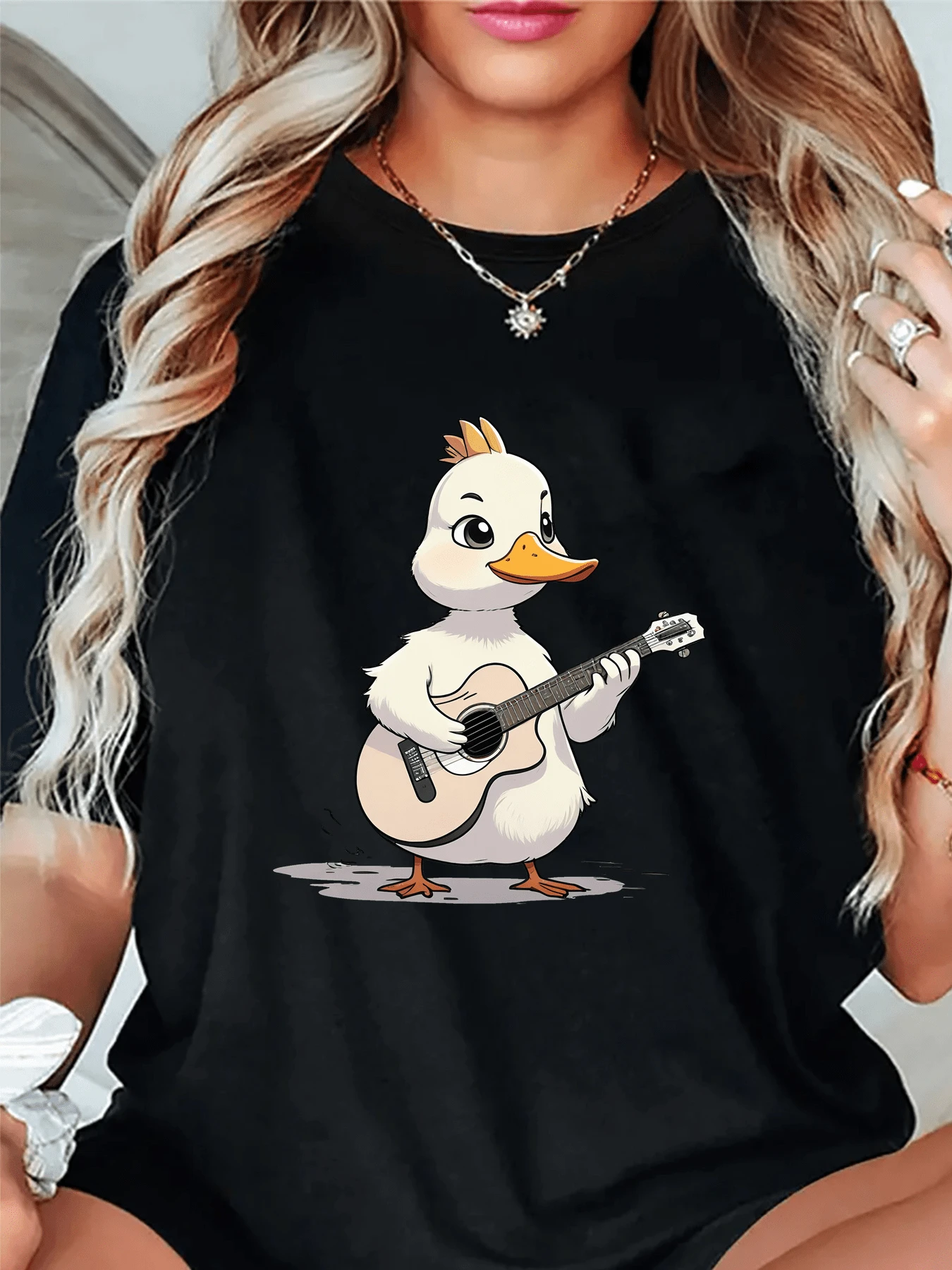 Patito sonriente tocando una guitarra transmitiendo alegría música y paz con su mirada dulce ideal para espíritus creativos y amantes del arte camiseta de mujer casual moderna confortable - Negro - Ver 1