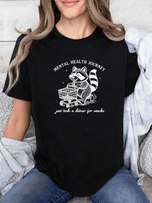 Smiling Raccoon Pushing A Shopping Cart Symbolizes Tenderness, Humor, And Self-Care On The Path To Mental Well-Being. Women's Casual, Modern, Comfortable, And Fun T-Shirt - 黑色 - 查看 1