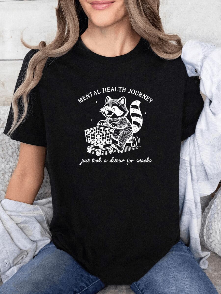 Smiling Raccoon Pushing A Shopping Cart Symbolizes Tenderness, Humor, And Self-Care On The Path To Mental Well-Being. Women's Casual, Modern, Comfortable, And Fun T-Shirt - 黑色 - 查看 1