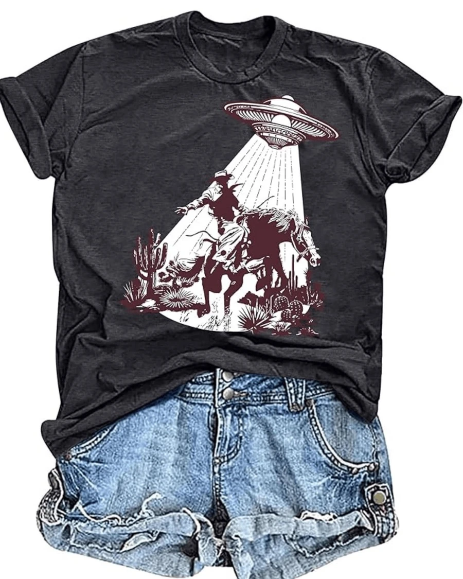 Cowboy enfrentando una nave espacial que desciende del cielo sobre un desierto lleno de cactus representando un encuentro misterioso entre lo terrenal y lo desconocido camiseta de mujer casual moderna cómoda para uso diario - Negro - Ver 1