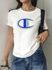 Embroidered Symbol In The Shape Of An Abstract Letter Evoking Balance, Strength, And Modernity In Blue And White Tones. Casual, Comfortable Women's T-Shirt, Ideal For Everyday Wear With An Elegant Touch. - 白色 - 查看 1