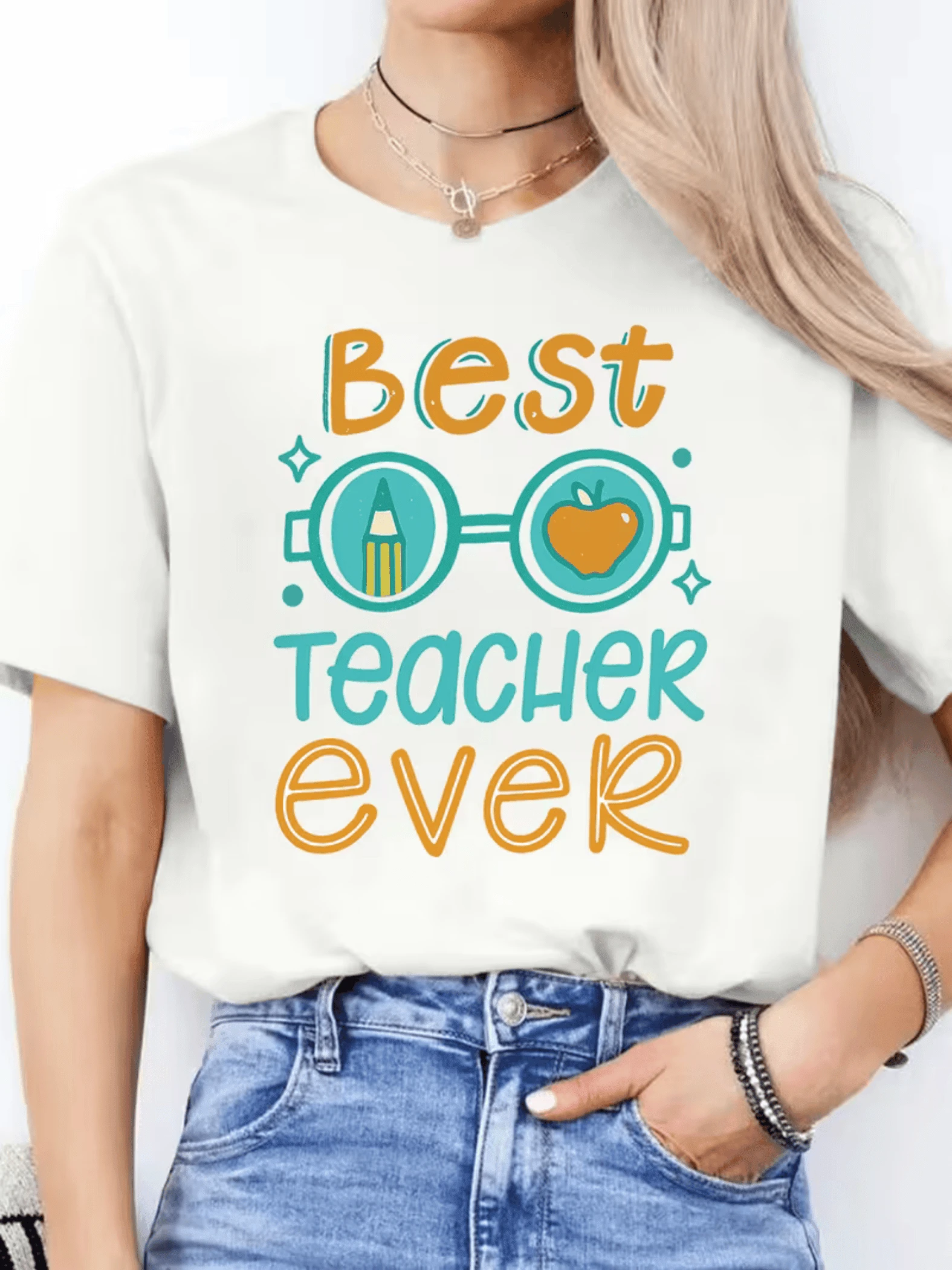 Colorful Text With Cheerful Lettering Celebrating The Best Teacher In The World, Accompanied By A Pencil And An Apple, Symbols Of Knowledge And Gratitude. Ideal For Expressing Appreciation. Comfortable Casual Women's T-Shirt For Everyday Wear. - 白色 - 查看 1