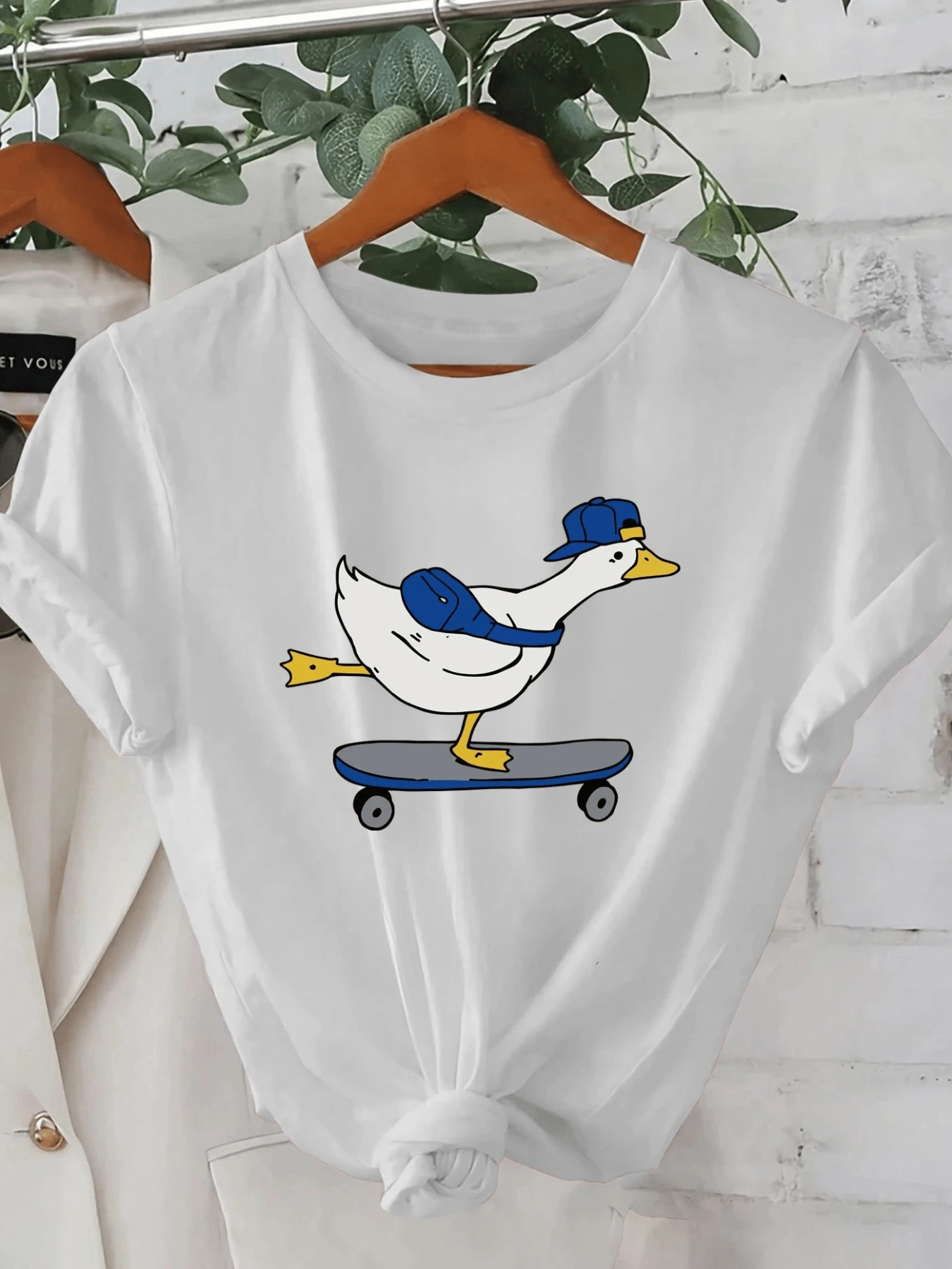 Adventurous Duck Wearing A Blue Cap On A Skateboard, Showing Free Spirit And Fun Energy. Ideal For Those Who Love Originality. Modern And Comfortable Casual Women's T-Shirt. - 白色 - 查看 1