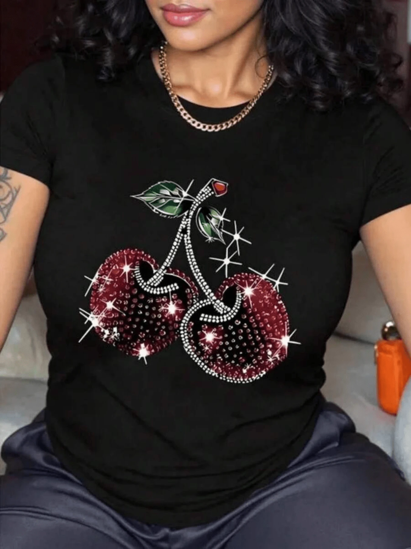 Two Bright Red Cherries Joined By Stems With Green Leaves Symbolizing Energy, Love, Passion, And Freshness, Reflecting Feminine Vitality And Elegant Charm. A Modern, Casual Women's T-Shirt With A Glitter Effect. - 黑色 - 查看 1