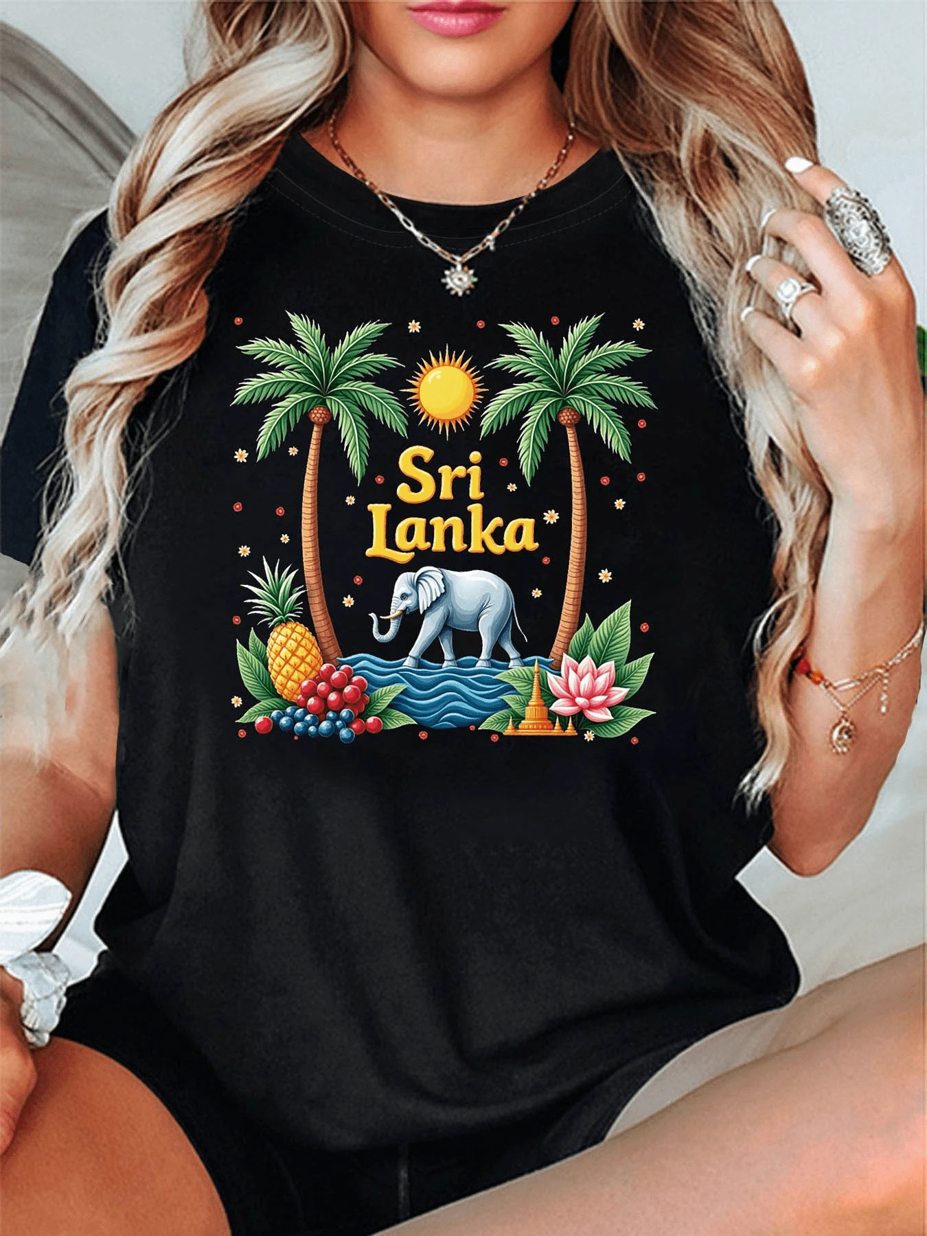 Sol radiante sobre palmeras tropicales junto a un majestuoso elefante rodeado de frutas exóticas flores de loto y símbolos de calma y naturaleza que evocan la belleza de Sri Lanka camiseta de mujer casual moderna cómoda y atractiva - Negro - Ver 1