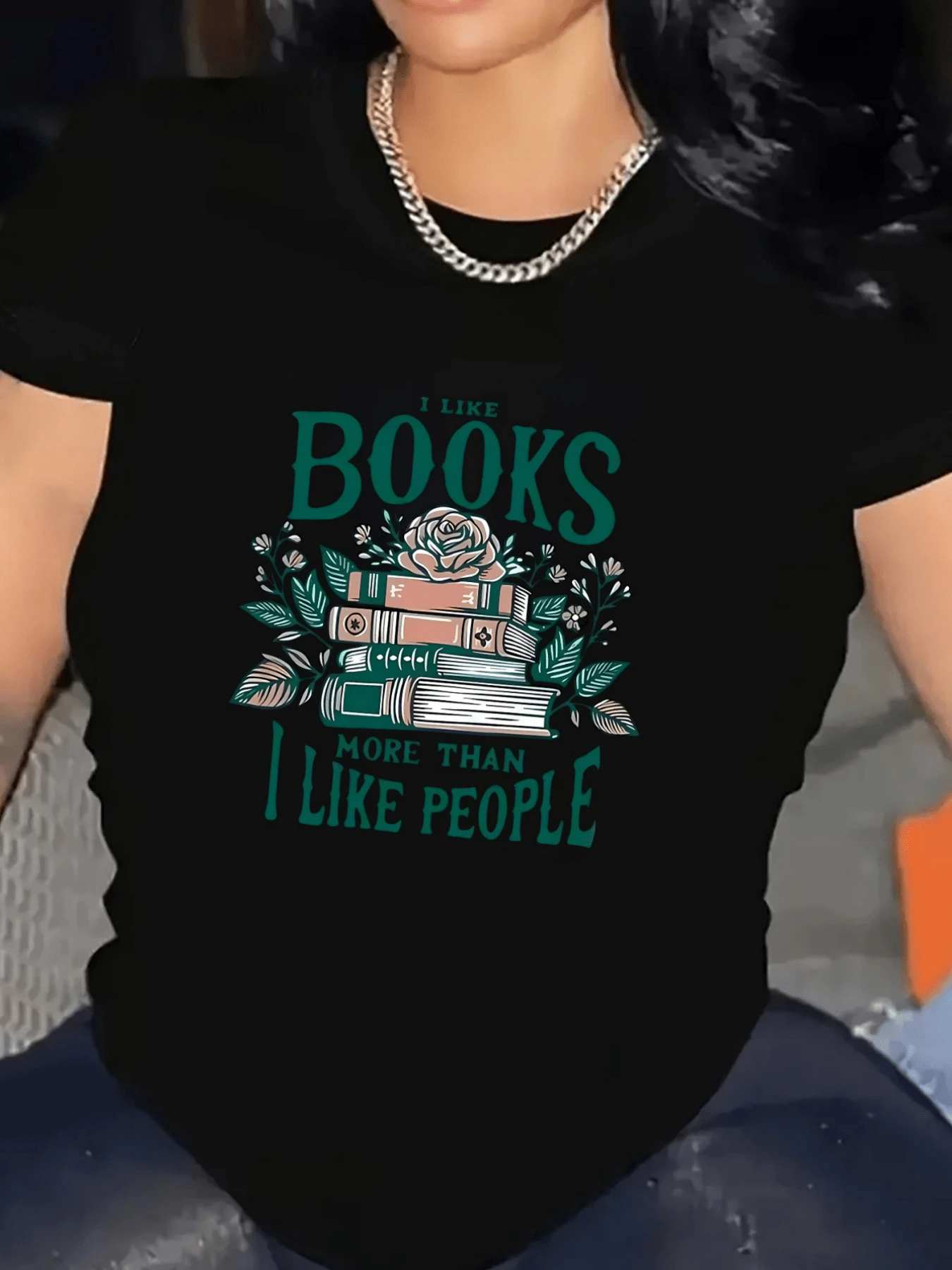 Rosa sobre una pila de libros simboliza el amor por la lectura y la tranquilidad que brindan las páginas abiertas junto a frases que expresan una conexión profunda con los libros camiseta de mujer casual cómoda ideal para amantes de la lectura - Negro - Ver 1