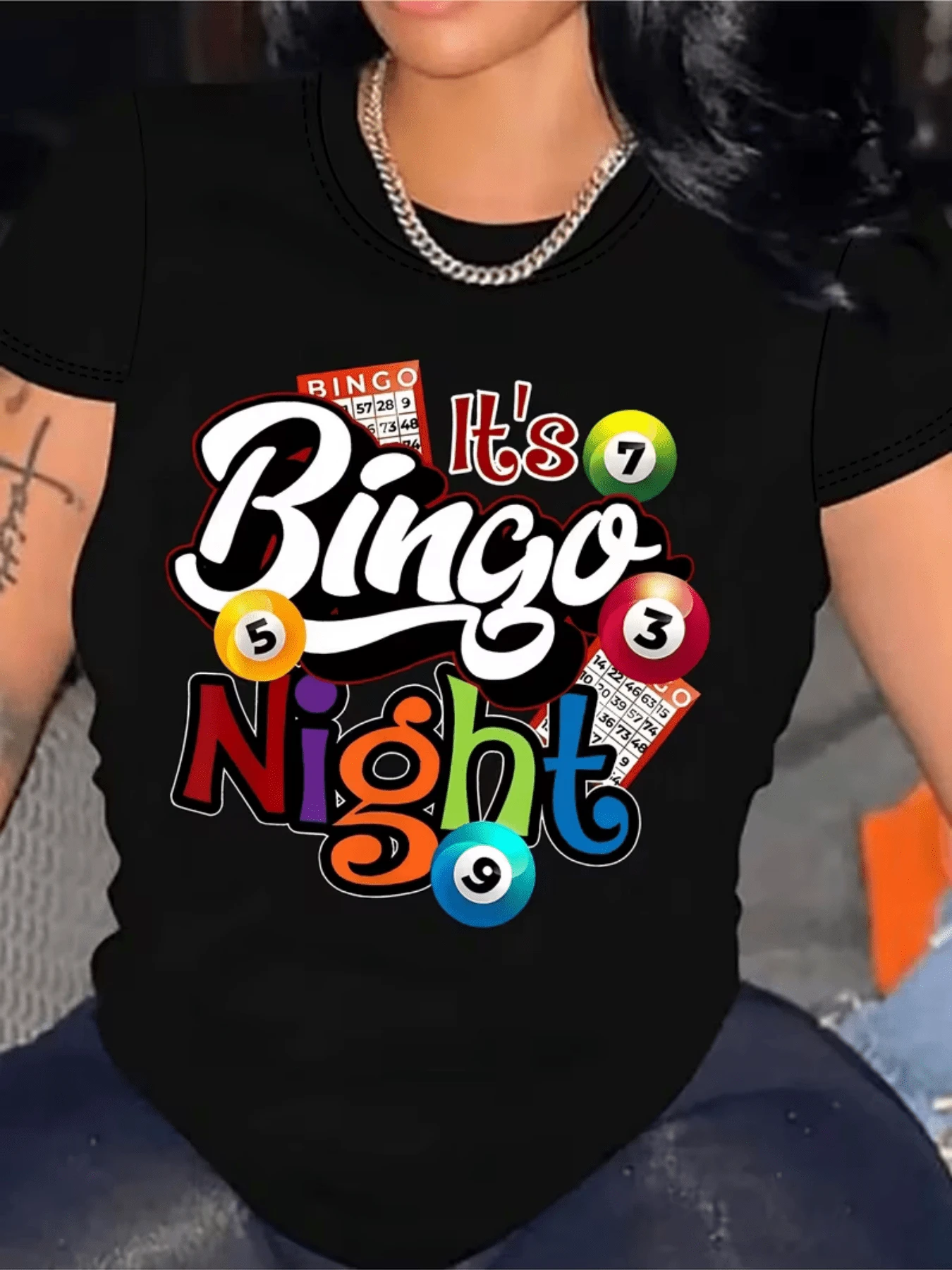Coloridas bolas numeradas junto a tarjetas de bingo que evocan momentos alegres y la emoción de ganar en una noche divertida con amigos camiseta de mujer casual moderna para uso diario - Negro - Ver 1