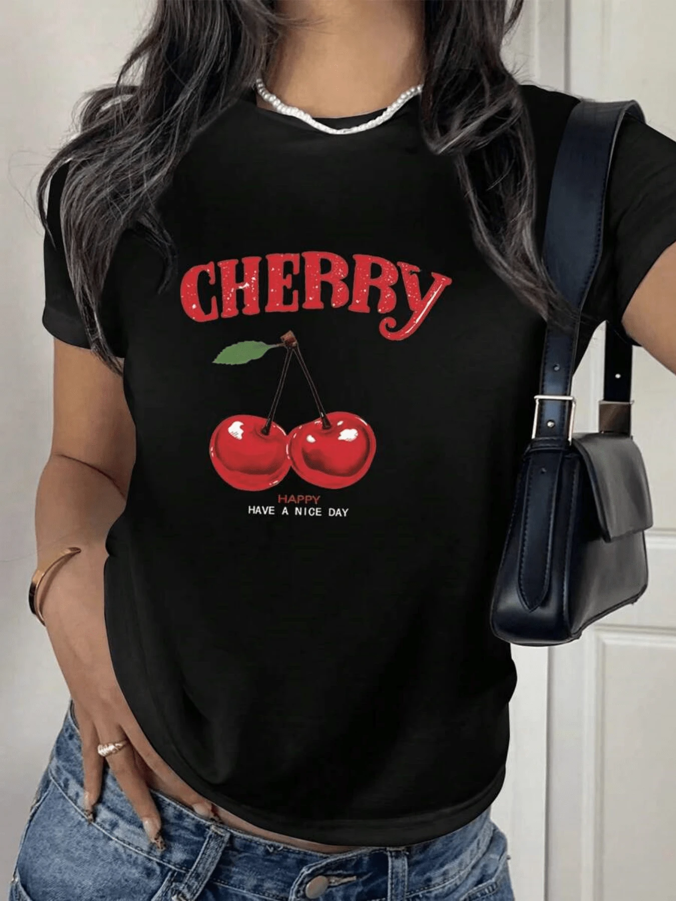 Dos cerezas rojas brillantes unidas por un tallo verde simbolizan alegría frescura y energía positiva transmitiendo un mensaje de optimismo y buen día camiseta de mujer moderna casual cómoda para verano - Negro - Ver 1