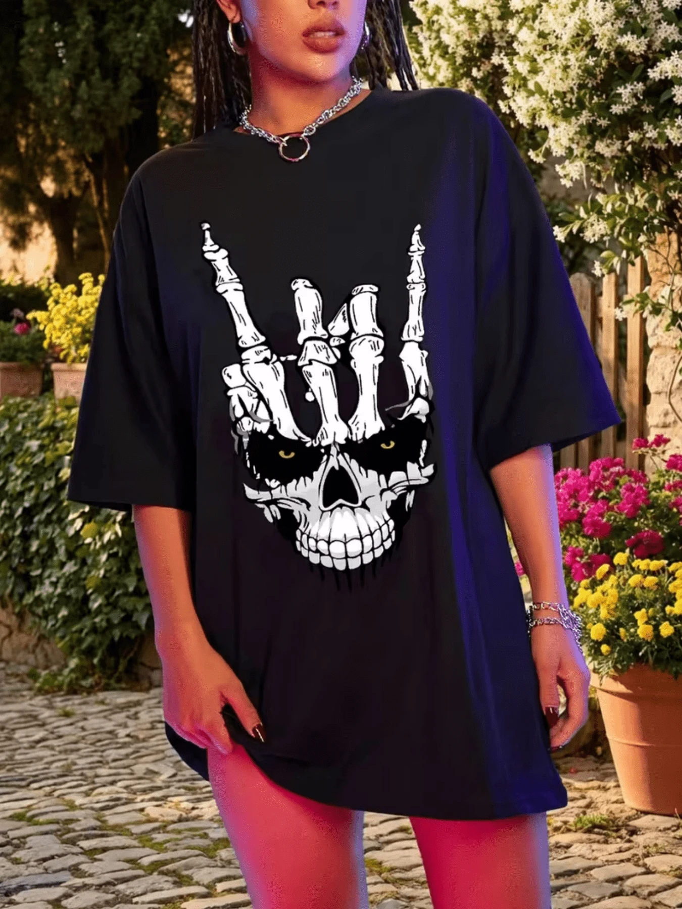 Mano esquelética levantando gesto de poder sobre calavera con ojos dorados que brilla en la oscuridad reflejando fuerza misterio y audacia perfecta para espíritus rebeldes camiseta de mujer moderna casual - Negro - Ver 1