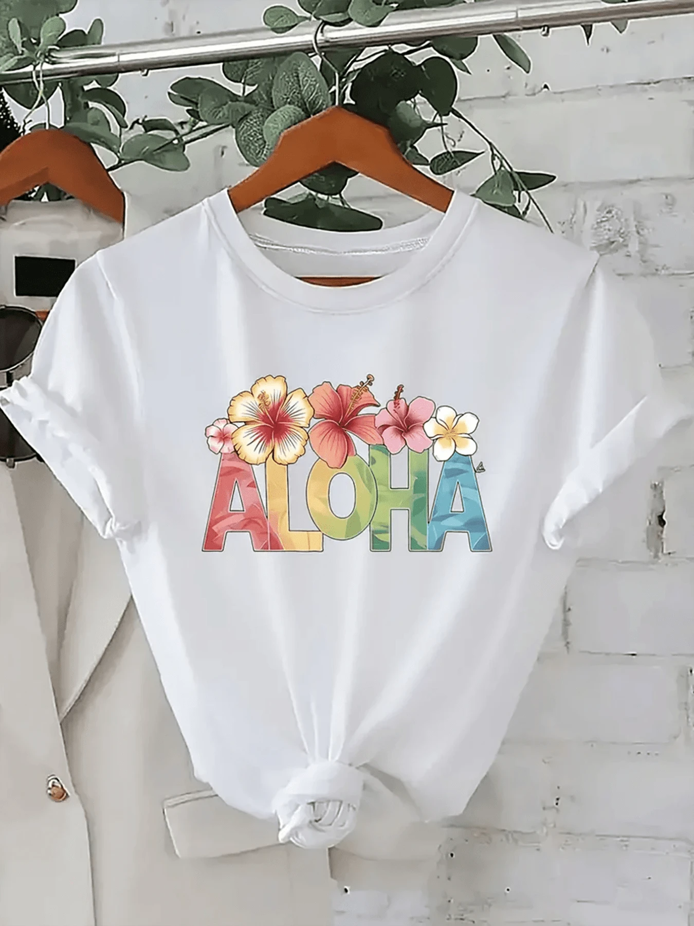 Palabra ALOHA con flores tropicales que representan la alegría del verano y el espíritu relajado de las islas transmitiendo energía positiva y frescura camiseta de mujer casual cómoda para días soleados - Blanco - Ver 1