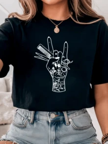 Mano alzada con símbolos de belleza luna tijeras peine y rosa que representan la energía creativa femenina y la pasión por el arte camiseta de mujer casual moderna cómoda para uso diario - Negro - Ver 1