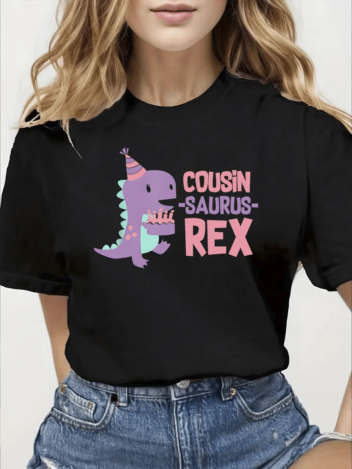 Dinosaurio alegre con sombrero de fiesta sostiene una tarta color pastel transmitiendo diversión familiar y energía juvenil perfecta para reuniones y momentos felices camiseta de mujer casual divertida moderna cómoda - Negro - Ver 1