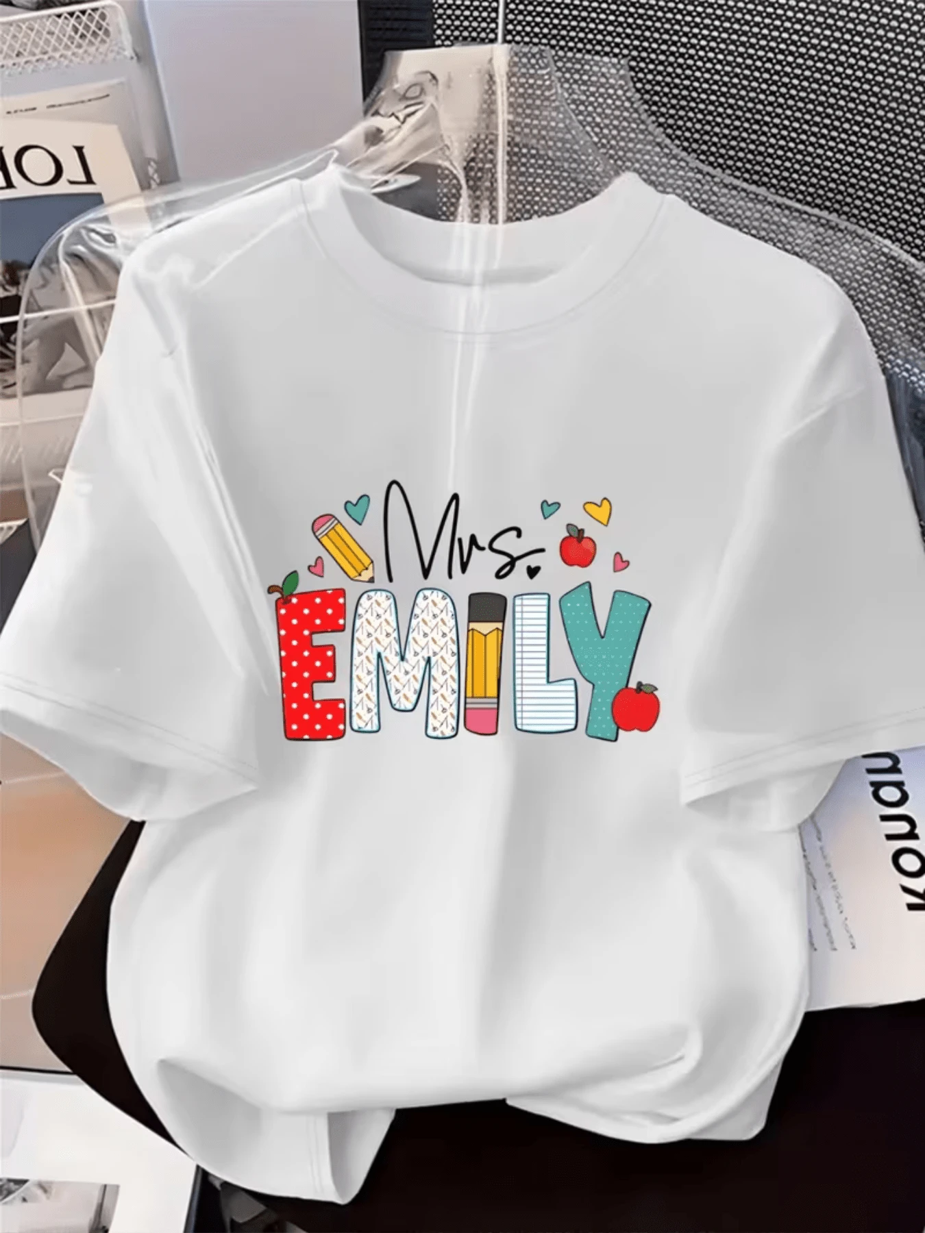 Mensaje colorido con letras decoradas que muestran alegría creatividad y símbolos como corazones lápiz y manzana representando educación y cariño ideal para maestras camiseta de mujer casual divertida para uso diario - Blanco - Ver 1