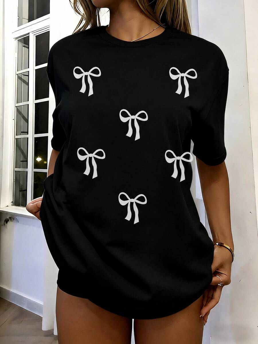 Playera negra oversize para mujer con estampado de moños blancos, manga corta cuello redondo, camiseta casual juvenil para diario y verano - Negro - Ver 1