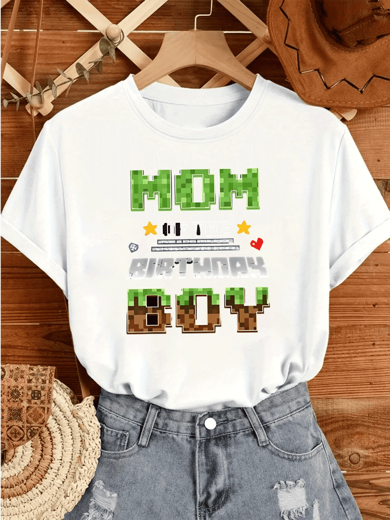 Texto con bloques verdes y marrones que evocan un mundo digital con estrellas y corazones simbolizando alegría familiar y celebración camiseta de mujer casual blanca cómoda para uso diario - Blanco - Ver 1