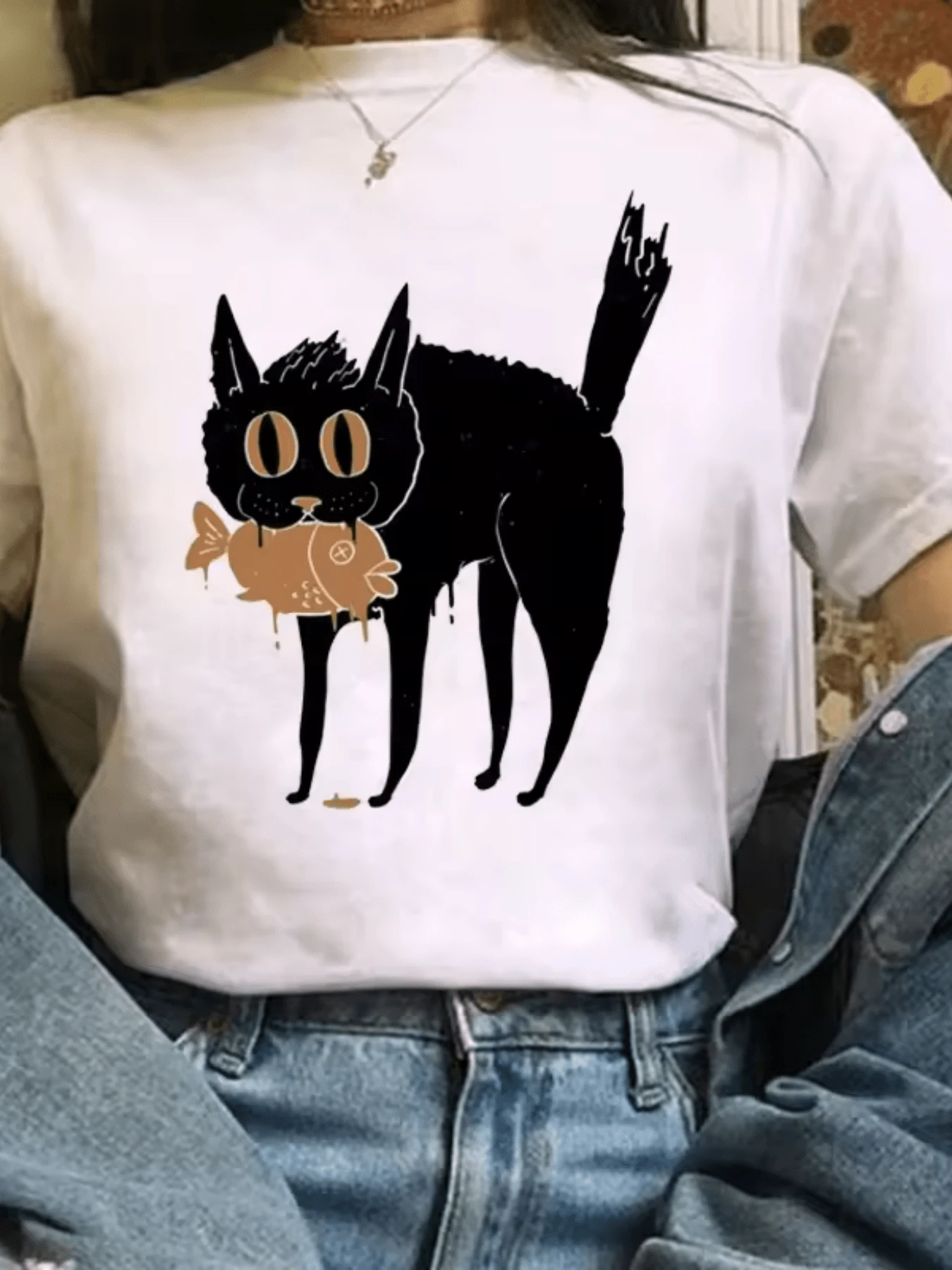 Gato negro con grandes ojos y expresión curiosa que sostiene un pez dorado simbolizando intuición curiosidad y equilibrio natural camiseta de mujer casual moderna para uso diario - Blanco - Ver 1