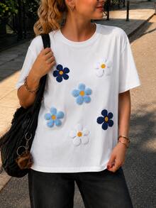 Camiseta Blanca de Mujer con Apliques de Flores en Azul y Blanco, Manga Corta, Cuello Redondo, Corte Holgado Casual, Diseño Floral Texturizado, Ideal para Primavera y Verano, Estilo Juvenil y Cómodo para Uso Diario - Blanco - Ver 1