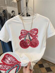 Dos cerezas brillantes adornadas con lentejuelas rojas y un lazo que simboliza alegría frescura y encanto femenino reflejando vitalidad en cada detalle camiseta de mujer casual moderna para verano - Blanco - Ver 1