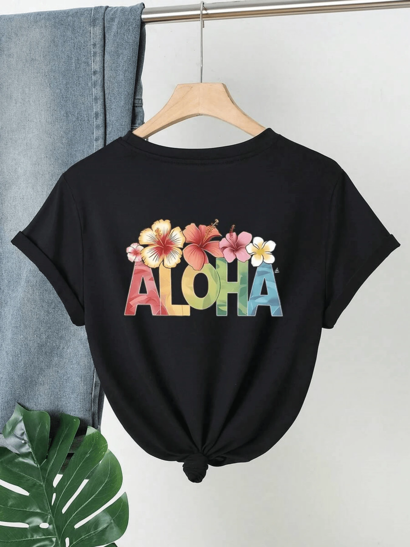 Palabra ALOHA con flores tropicales que representan la alegría del verano y el espíritu relajado de las islas transmitiendo energía positiva y frescura camiseta de mujer casual cómoda para días soleados - Negro - Ver 1