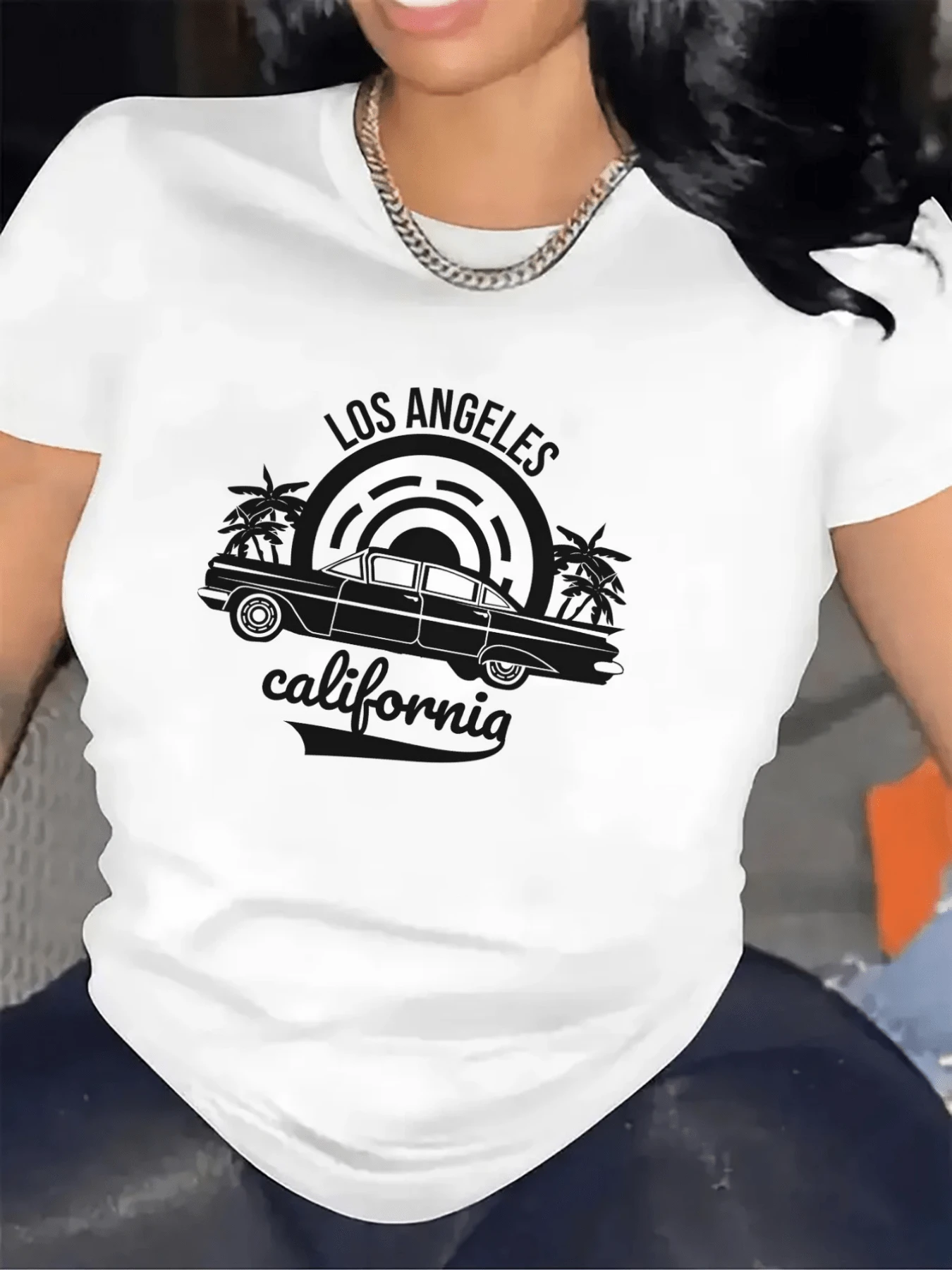 Auto antiguo bajo palmeras bajo el sol representando la energía relajada y el espíritu libre de las calles de Los Ángeles con letras que evocan aventura y verano camiseta de mujer casual urbana moderna - Blanco - Ver 1