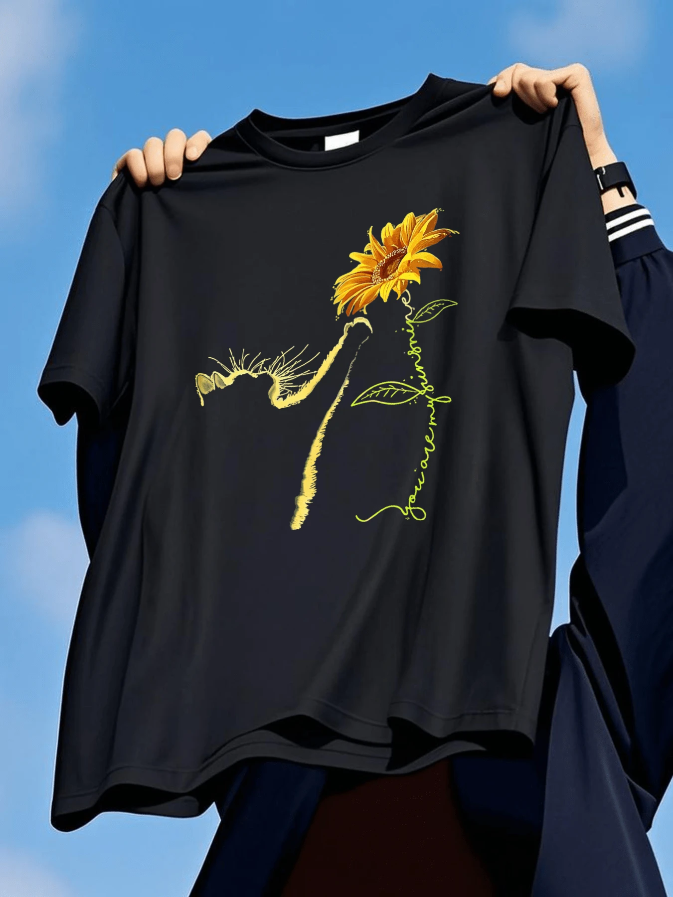 Flor de girasol que simboliza la fuerza interior y la esperanza renaciendo con la luz del sol acompañada del gesto delicado de un gato que representa curiosidad y calma camiseta de mujer casual moderna - Negro - Ver 1