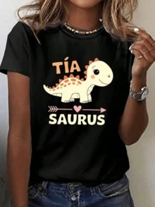 Un simpático dinosaurio sonriente con tonos suaves y pequeños detalles naranjas que transmiten alegría y ternura simboliza amor familiar y diversión camiseta de mujer casual cómoda para uso diario - Negro - Ver 1