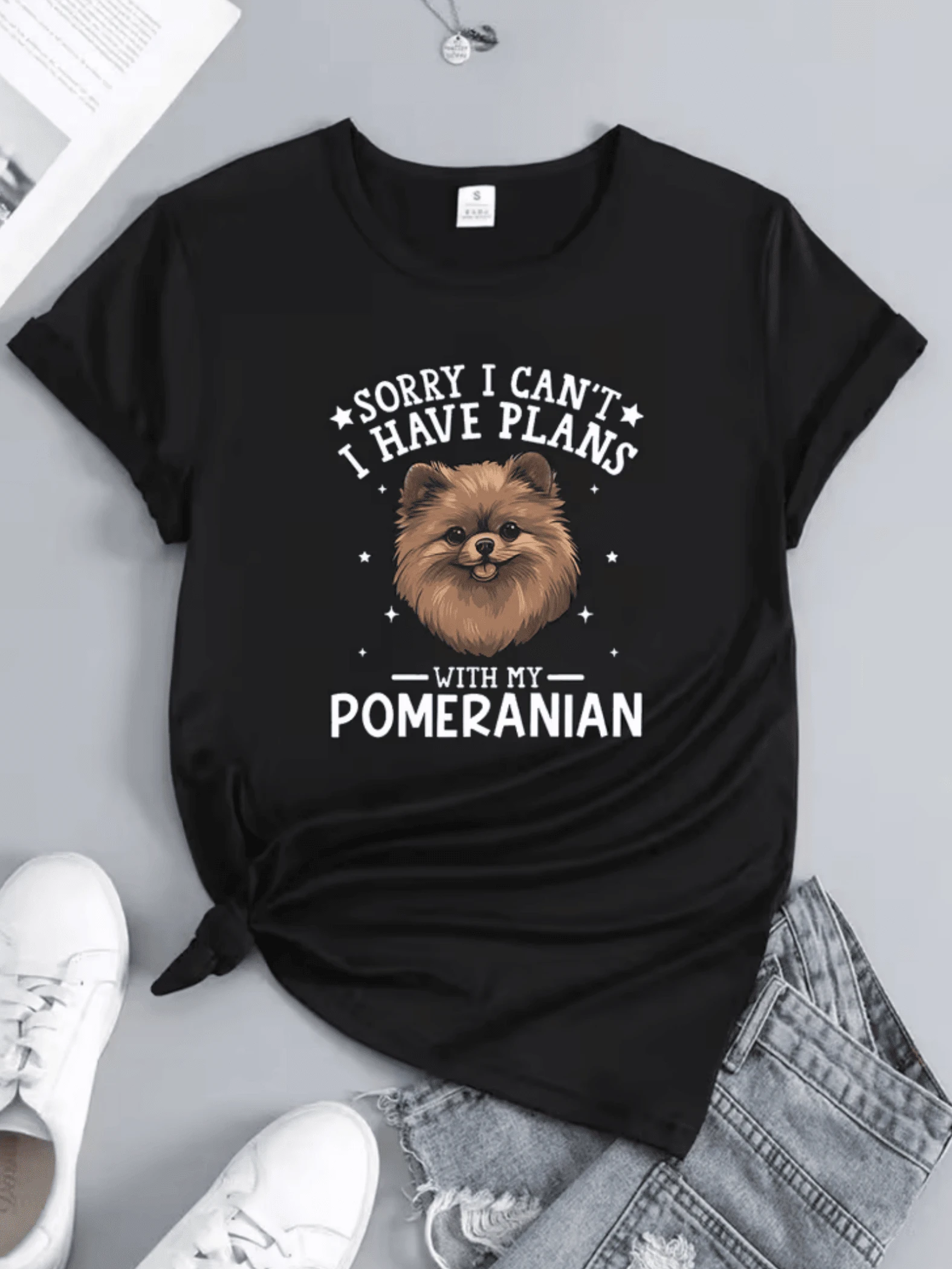 A Drawing Showing An Adorable Pomeranian Dog With A Friendly Expression Surrounded By Stars Conveys Fun And Love For Pets. A Comfortable, Casual Women's T-Shirt Perfect For Dog Lovers. - 黑色 - 查看 1