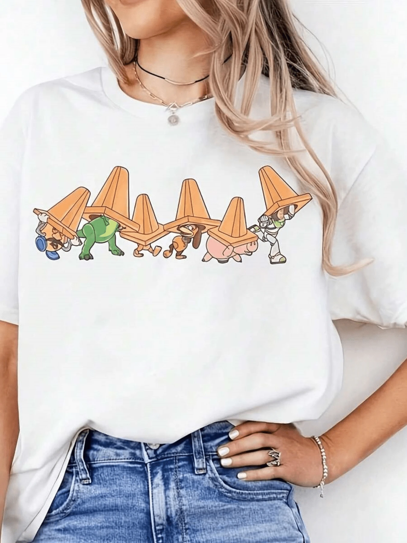 Personajes animados caminando juntos llevando conos naranjas sobre la cabeza simbolizando unión amistad y trabajo en equipo con toque divertido camiseta de mujer casual moderna - Blanco - Ver 1