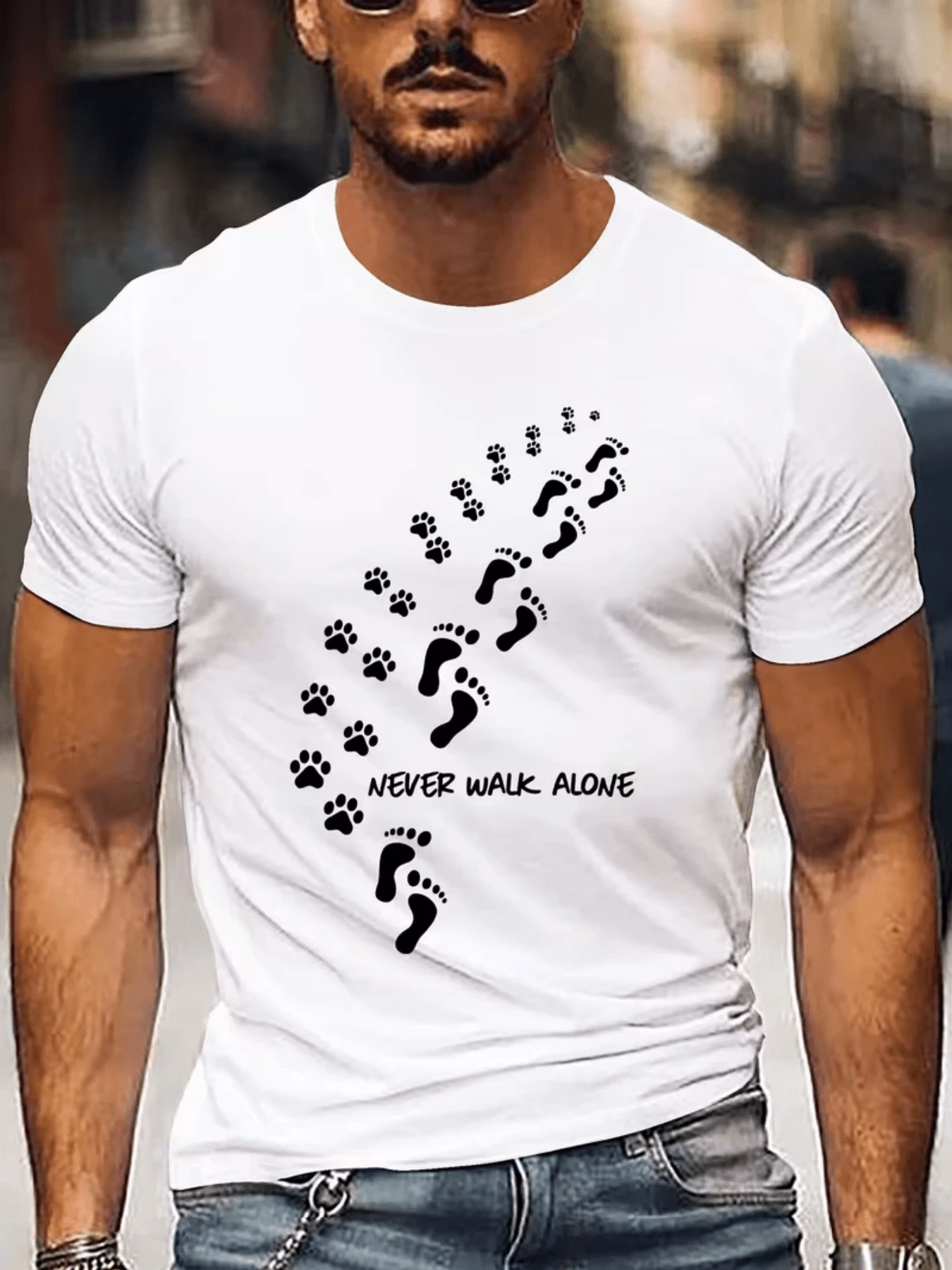 Huellas de pies y patas combinadas que suben por la prenda simbolizando un camino compartido de apoyo y lealtad un mensaje potente para quienes valoran la compañía en cada paso un recordatorio visual de que nunca estamos solos en nuestras jornadas la solidaridad es clave esta camiseta de hombre es perfecta para expresar ese sentimiento profundo y duradero perfecta para uso diario y para aquellos que buscan ropa con significado. - Blanco - Ver 1