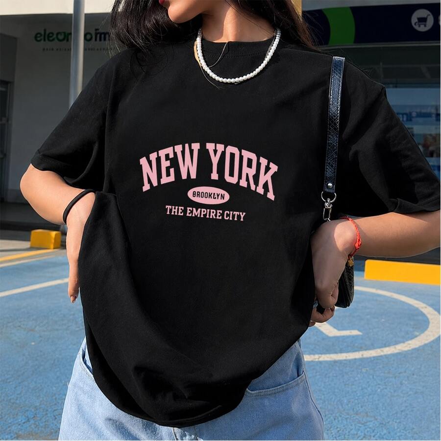 Playera negra con estampado tipográfico rosa de New York, estilo varsity y streetwear, camiseta gráfica manga corta, cuello redondo, outfit casual para mujer, uso diario, primavera verano - Negro - Ver 1