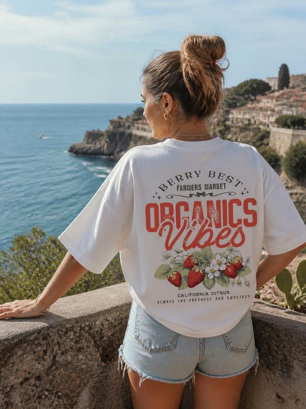 Camiseta feminina casual de verão, tamanho grande, com estampa vintage "Organics Vibes" de morango e flor, gola redonda e mangas curtas com ombros caídos.