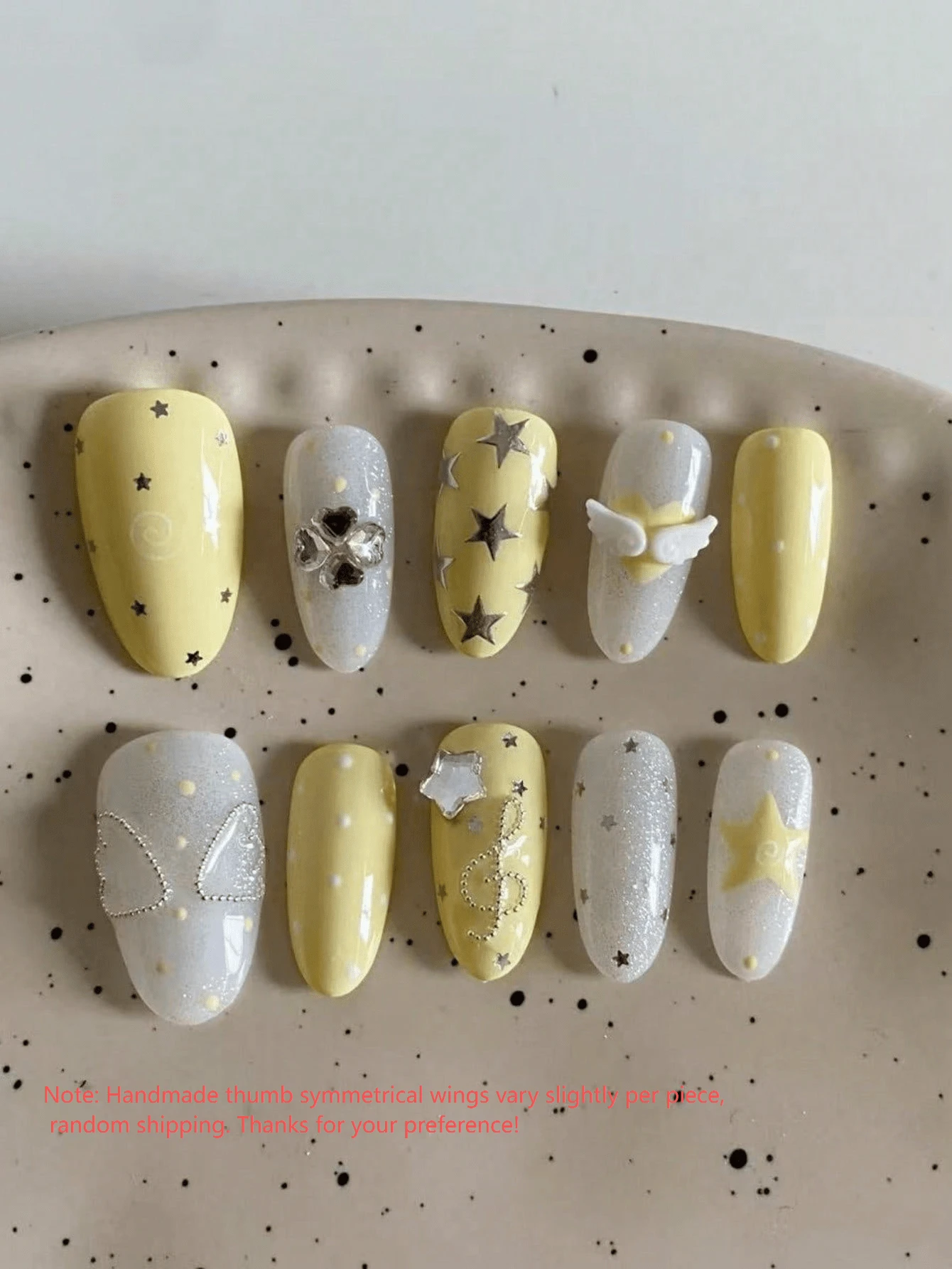10片手工橢圓形穿戴式美甲,春夏風格,奶油黃與銀色亮片底色,裝飾星星、天使之翼、三葉草水鑽與音符,清新甜美風,提亮膚色,適合日常配戴、約會與旅行,附果凍膠與美甲锉 - 黃色 - 查看 1